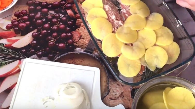 On top of the fish we spread the potatoes sliced in thin circles.