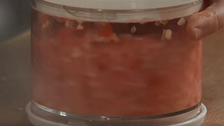 grind the garlic with pepper and tomatoes, preparing a kind of adjika.