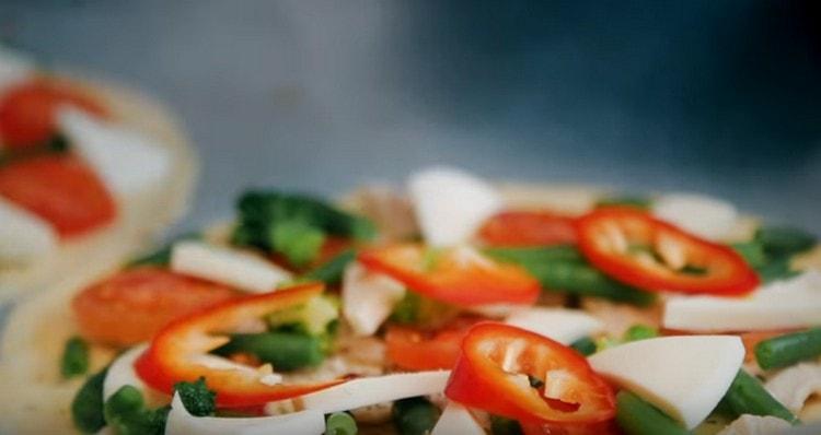 Then put on a pizza sliced ​​triangles mozzarella and pepper.