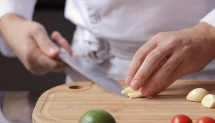 Crush the garlic with a knife.