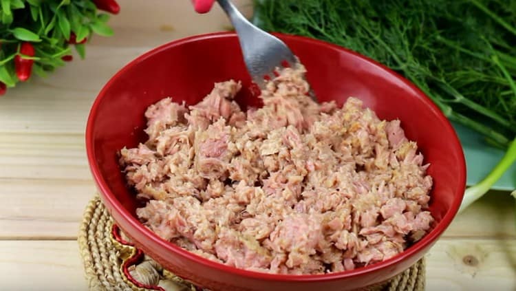 Knead the canned fish with a fork.