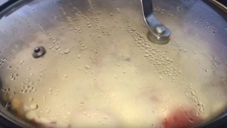 We cover the pan with a lid and let the pizza fry.