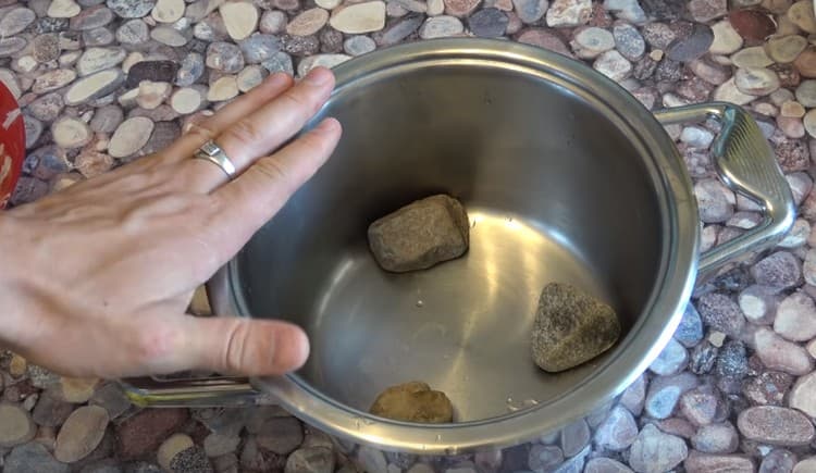 At the bottom of the pan we put small pebbles.