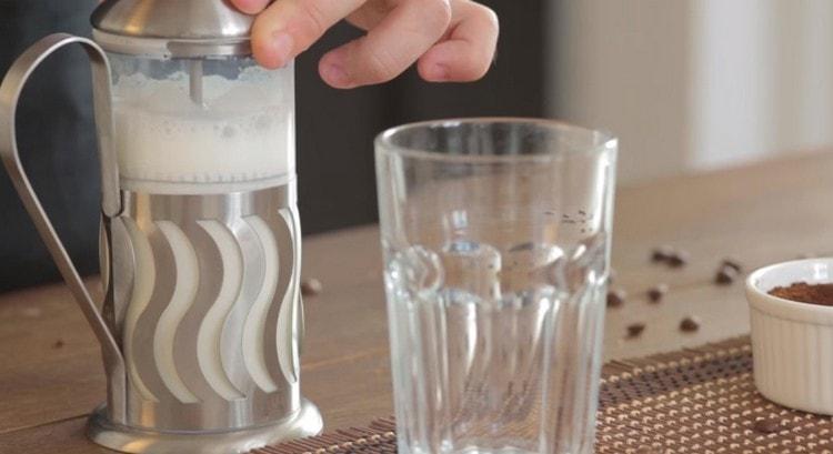 Pour hot milk into a French press and whip the foam.