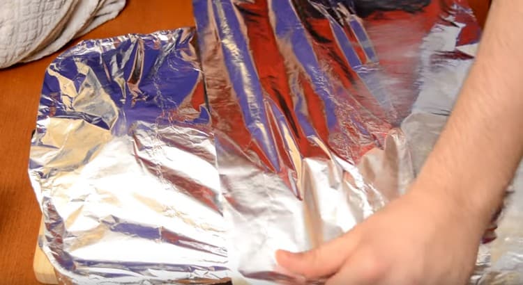 The baking tray with the rabbit is tightly covered with foil and sent to the oven.