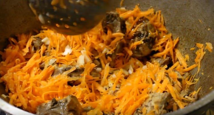 Add onions with carrots to the meat, stew the place.