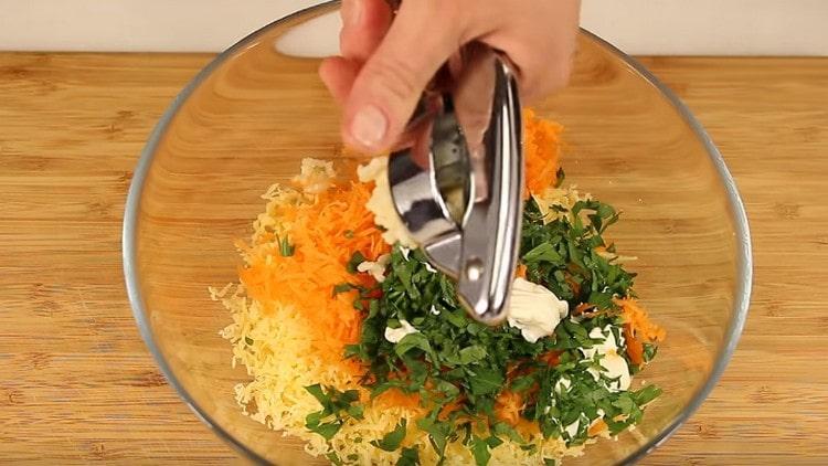 Cooking the filling of grated carrots and cheese. chopped herbs, garlic and mayonnaise.