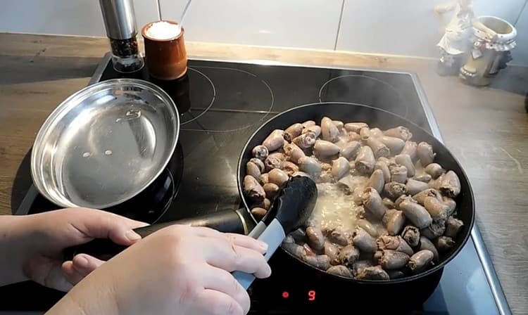 We spread the chicken hearts in the pan and fry until almost all the liquid has evaporated from them.