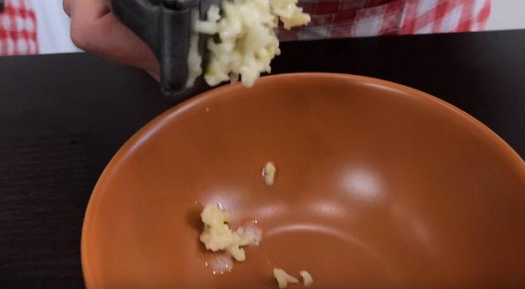 To prepare the sauce, squeeze garlic through a press.