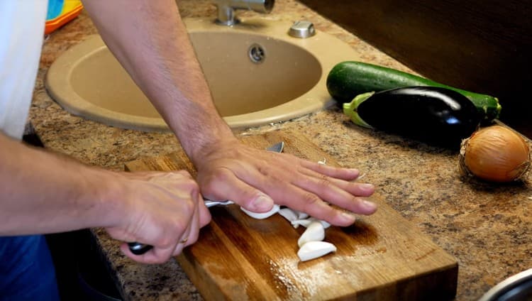 Peel and crush the garlic with a knife.