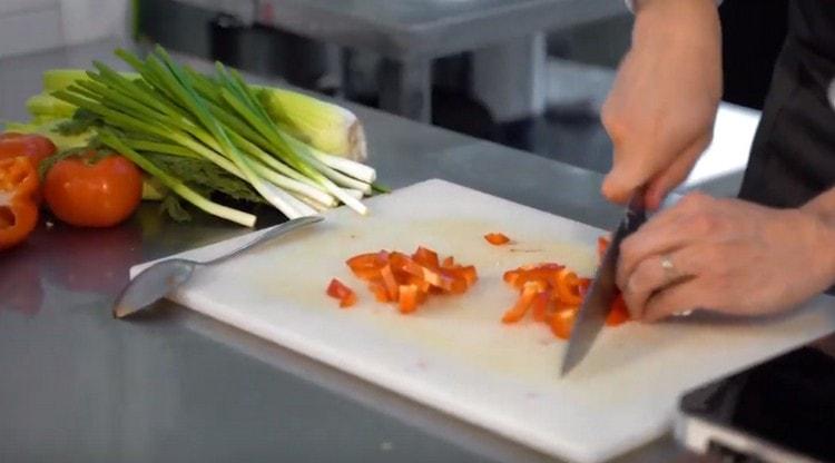 We chop the bell pepper and send it to the pan.