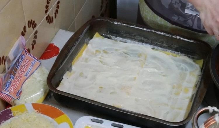 Grease a layer of sheets with bechamel sauce.