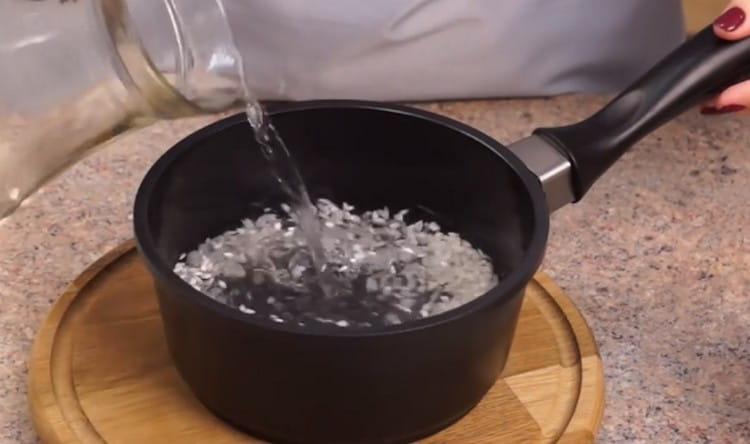 Pour rice with water and set to cook.