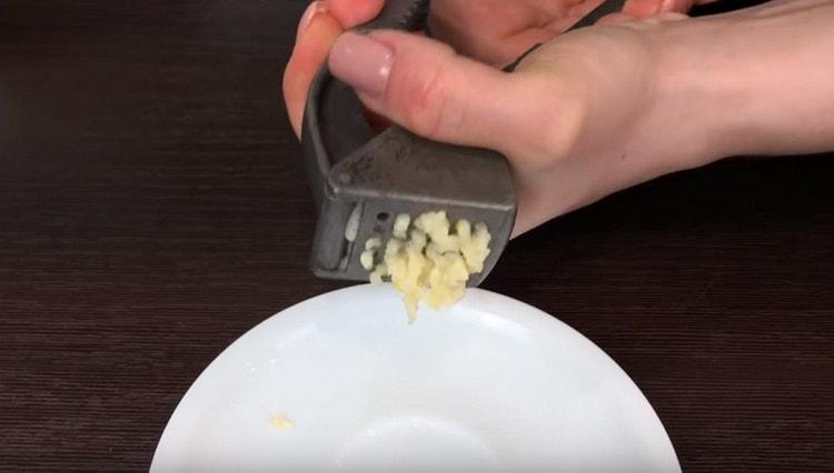 Pass the peeled garlic through a press.
