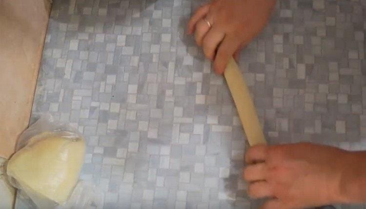 Cut a piece from the dough and roll it into a sausage.