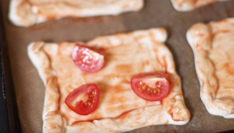 We spread the cherry tomato slices on the workpiece.