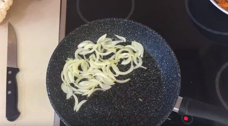 After the carrots, put the onion sliced ​​in half rings in the pan.