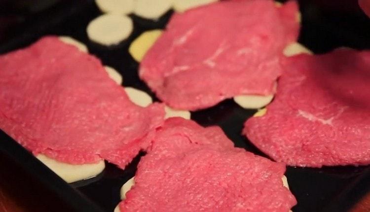 On top of the potatoes we lay out the beaten meat.