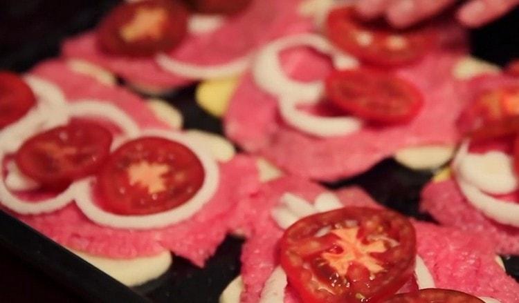cut the tomato into circles and spread them on the meat on top of the onion.