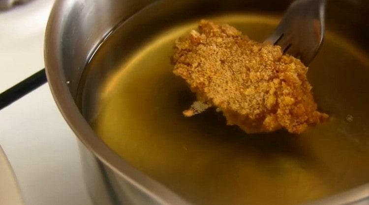 Gently lower the workpiece with a fork into the hot vegetable oil, it should completely cover the meat.