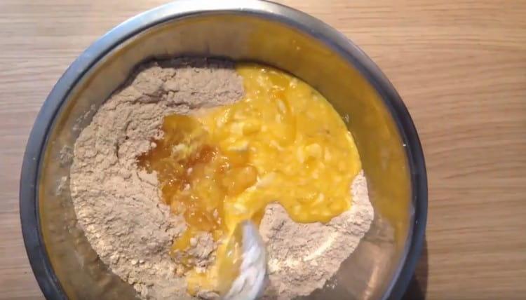 We introduce the liquid components into the flour and knead the dough.