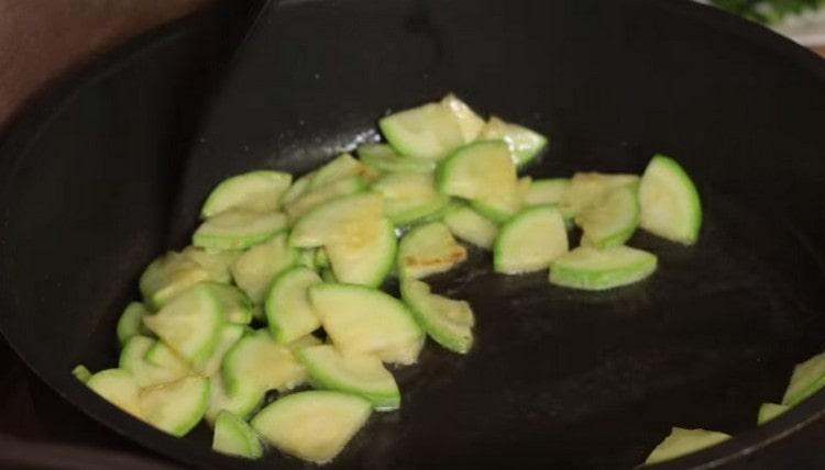 Fry zucchini in a pan, and then remove them.