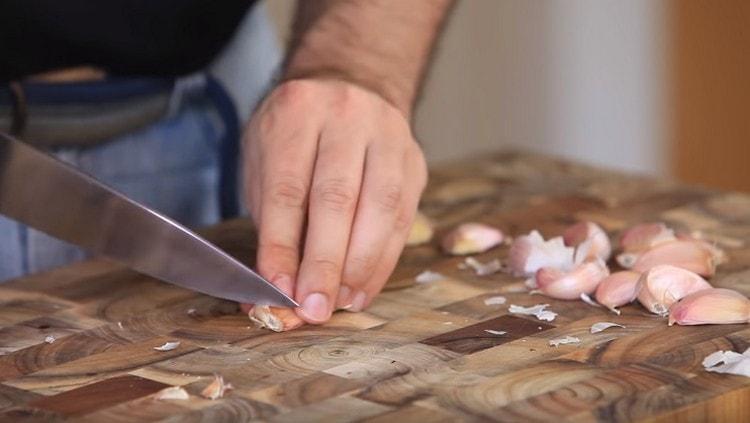 Peel the garlic and add it to the peppers in a blender.