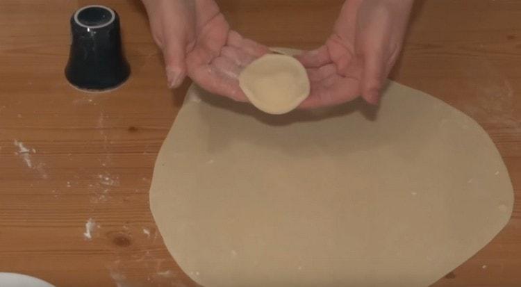 From the dough layer, squeeze the same blanks for dumplings with a glass.