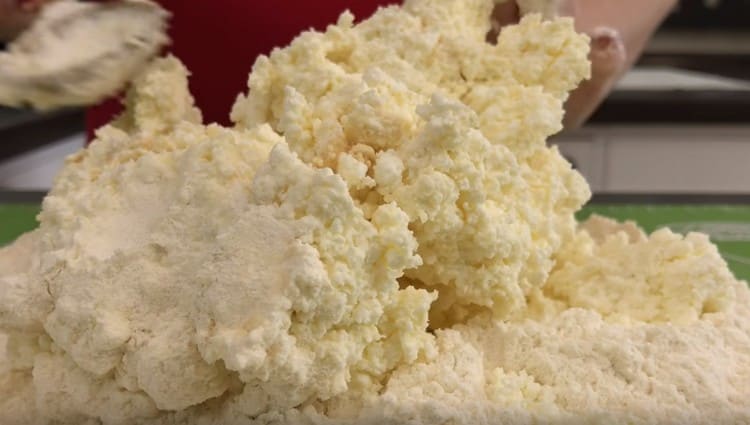 Having made a deepening in the flour, put the cottage cheese into it.