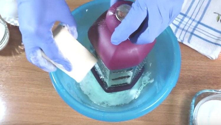 Grate cold butter in a dough bowl.