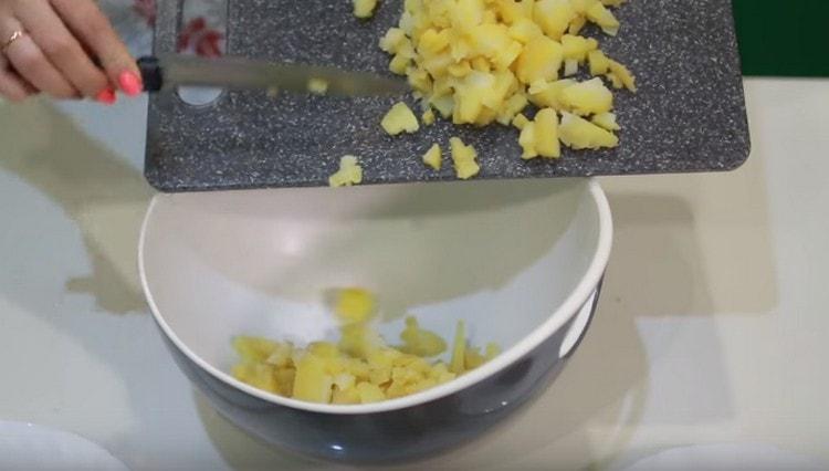 We shift the potatoes into a deep bowl to mix the salad.