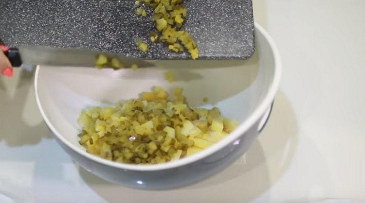 Add chopped cucumbers to the potatoes.