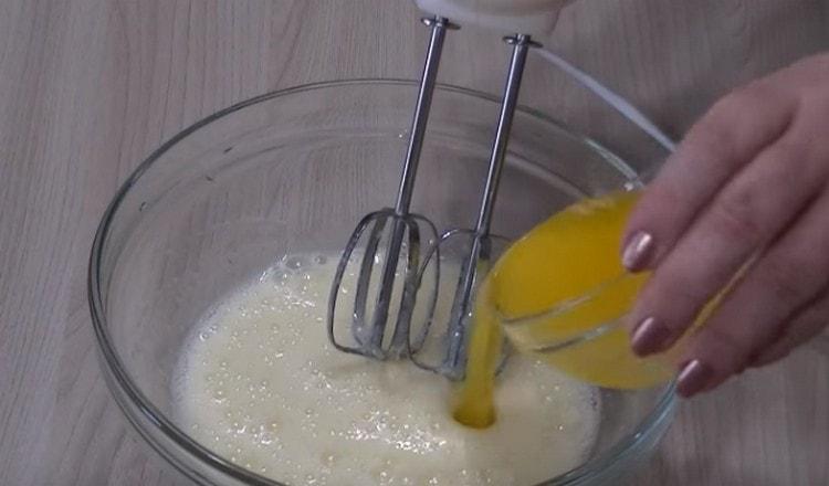 Enter the pre-melted butter into the egg mass.
