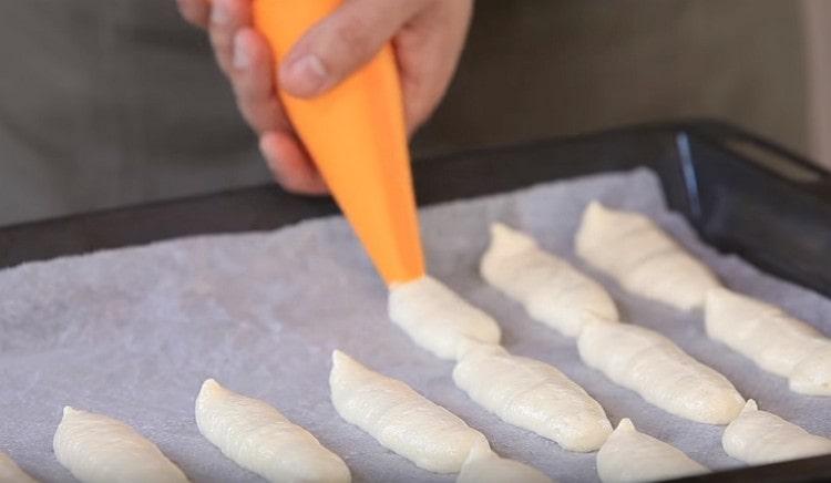 We place cookies in the form of fingers (or sticks) on a baking sheet covered with parchment.