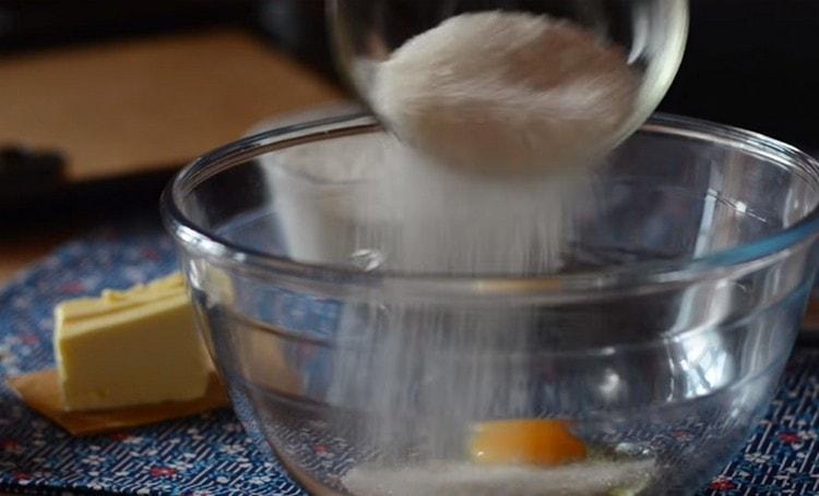 We beat out the egg from the bowl, add sugar.