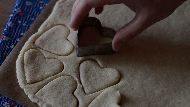 We cut out cookies from the dough with cookie cutters.