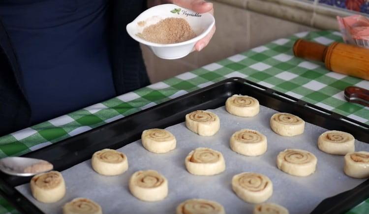 Having laid the blanks on a baking sheet covered with parchment, grease them again with oil and sprinkle with sugar and cinnamon.