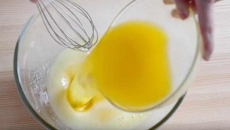 Pour melted butter into the egg mass.