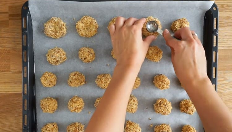 We make a depression in each cookie with a spoon.