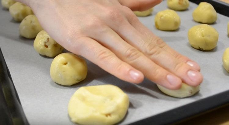 We lay out the blanks on a baking sheet covered with parchment, and gently press it.