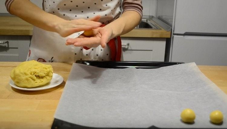 We roll small balls out of the dough and put them on a baking sheet covered with baking paper.