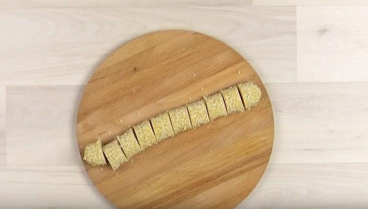 Roll the sausages of dough in sesame with sugar and cut into pieces.