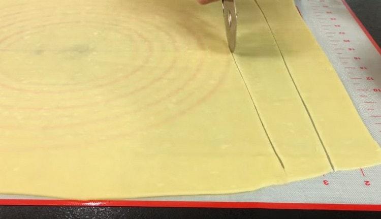 Cut the rolled dough into strips of equal width.