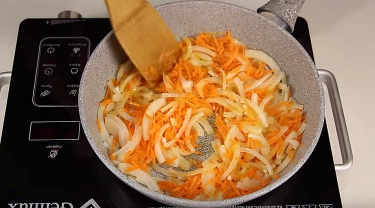 Fry onions with carrots in a pan.
