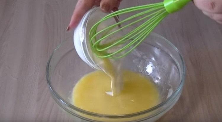 We introduce sour cream and vegetable oil into the egg mass.