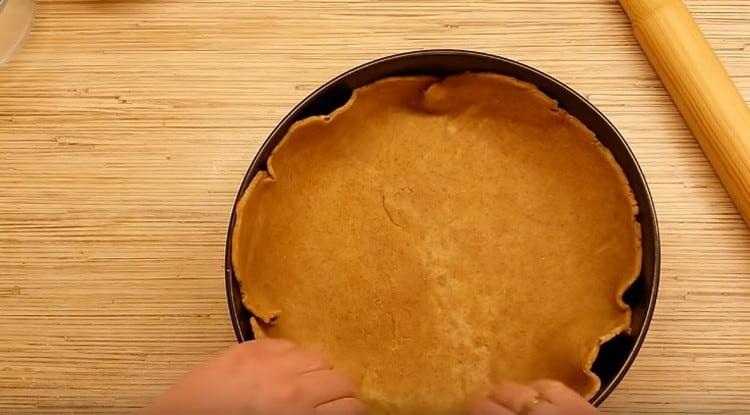 We shift the dough into the form, immediately make fairly high sides.