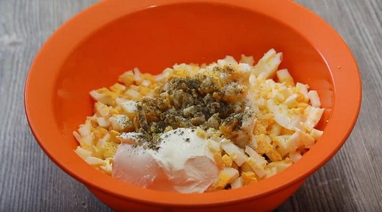 In a bowl, combine eggs with onions, add sour cream, season with salt and pepper.