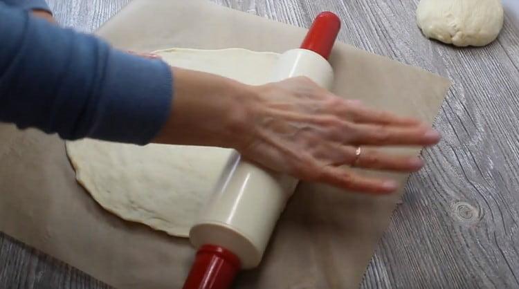 divide the dough into two identical parts and roll each of them thinly on a sheet of parchment.