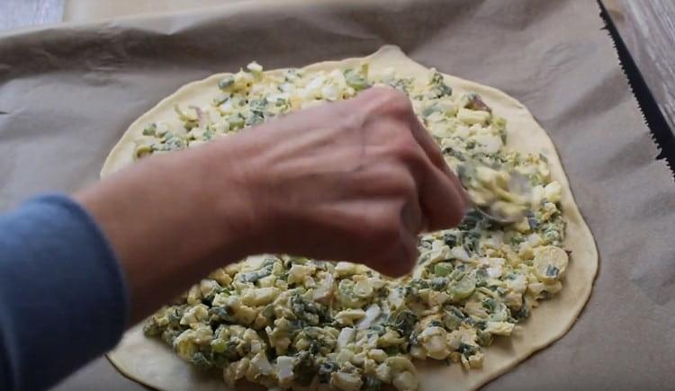 Spread the filling on the dough, 2-3 cm from the edge