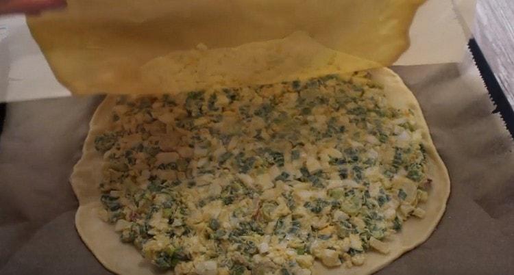 Cover the future pie with a second layer of dough.